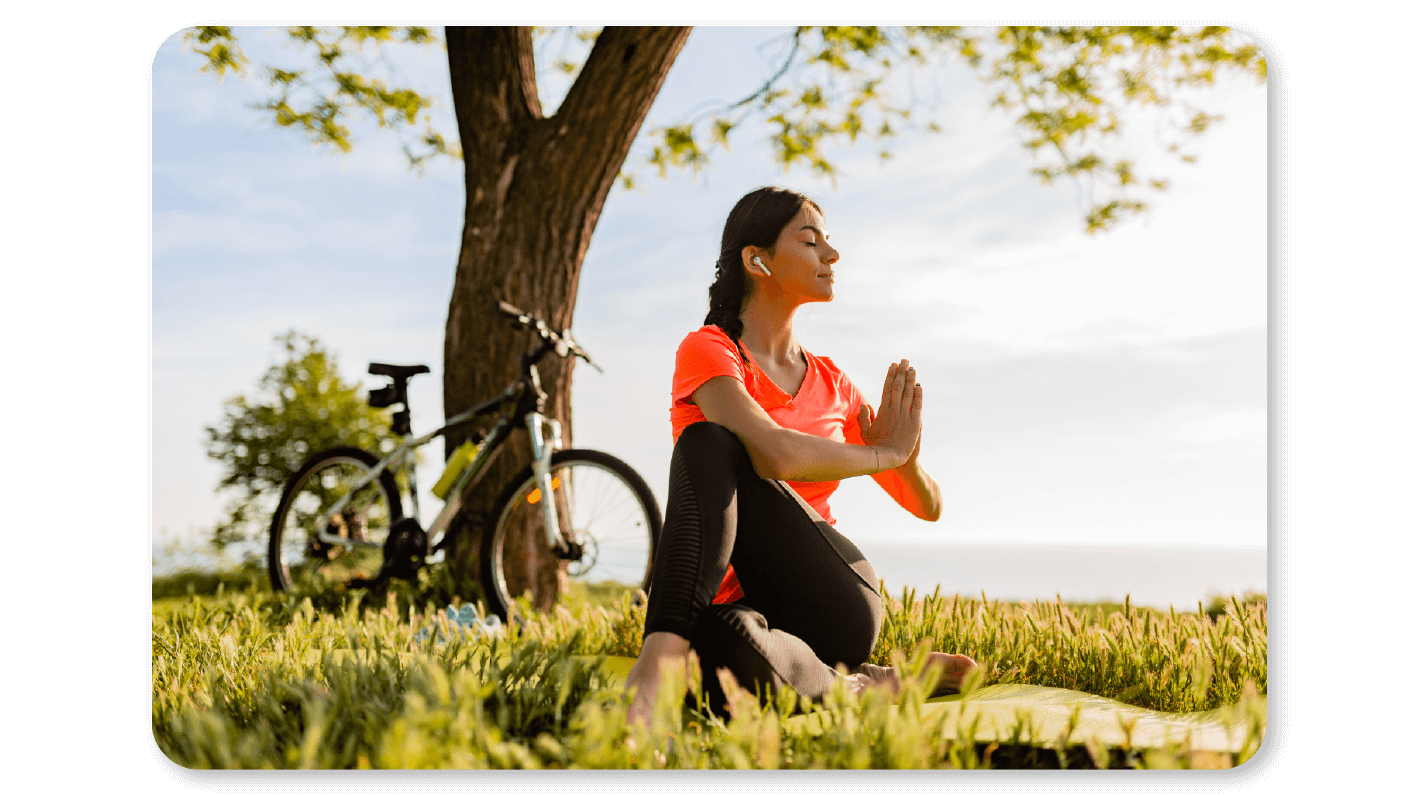 Wellness Rewards motivates a woman employee to do yoga under a tree and hence contributes to improving employee health
